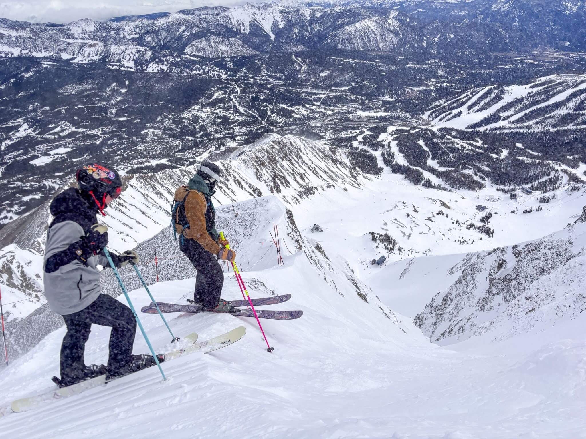Two skiers scoping out their line into the Big Coulier at Big Sky, MT